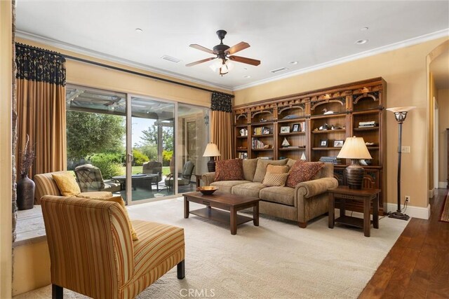 living room with ornamental molding, ceiling fan, and light hardwood / wood-style flooring