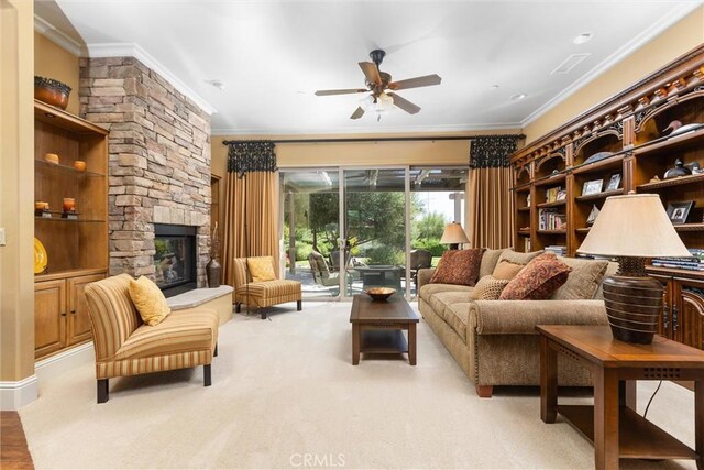 living room featuring ceiling fan, a stone fireplace, light colored carpet, and crown molding