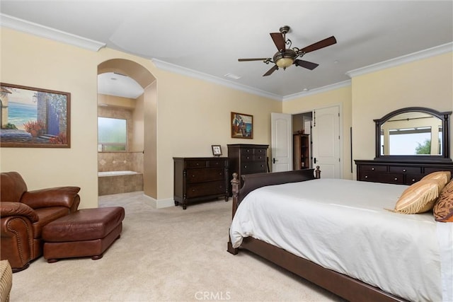 carpeted bedroom with ornamental molding, arched walkways, ensuite bathroom, and a ceiling fan