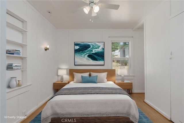 bedroom with ceiling fan, ornamental molding, and light hardwood / wood-style flooring