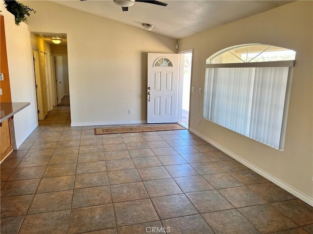 tiled entrance foyer featuring ceiling fan and lofted ceiling