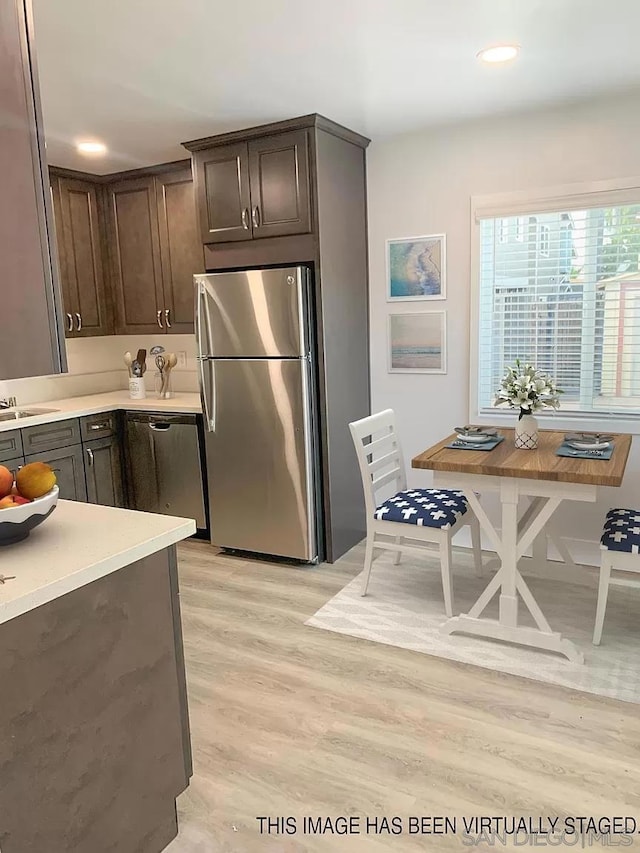 kitchen featuring light hardwood / wood-style flooring, dark brown cabinetry, and stainless steel appliances