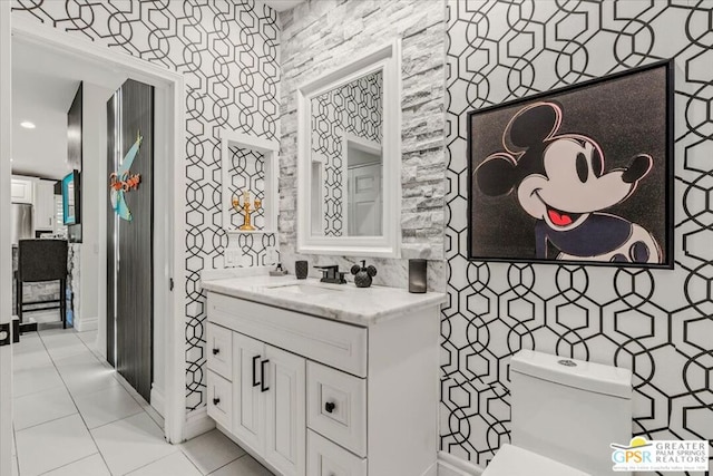 bathroom with vanity, toilet, and tile patterned floors