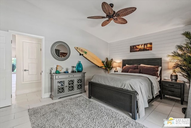 bedroom featuring ensuite bath, light tile patterned floors, vaulted ceiling, and ceiling fan