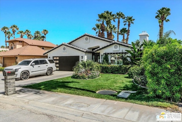 view of front of house with a garage and a front lawn