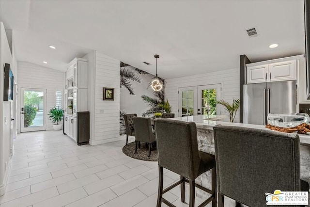 dining area featuring a wealth of natural light, lofted ceiling, and french doors