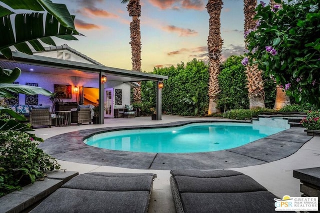 pool at dusk featuring a patio area