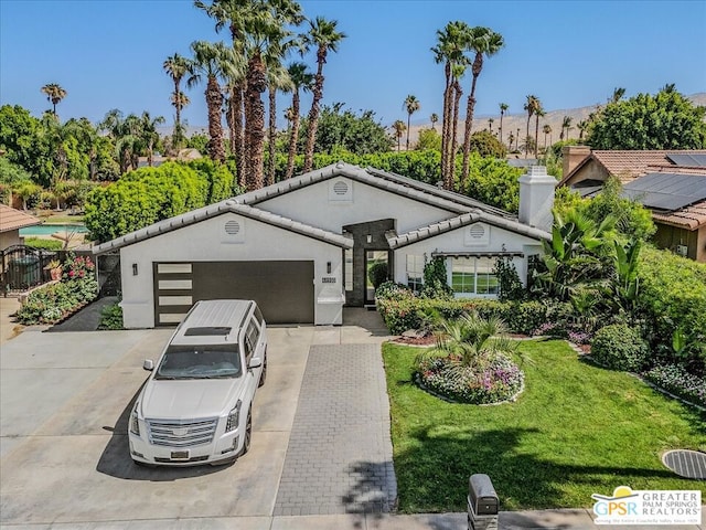 view of front of property with a garage and a front lawn