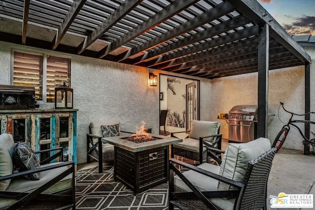 patio terrace at dusk featuring area for grilling, a fire pit, and a pergola