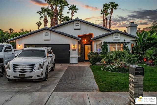 view of front of house featuring a yard and a garage