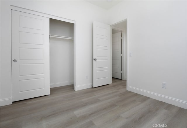 unfurnished bedroom featuring a closet and light hardwood / wood-style flooring