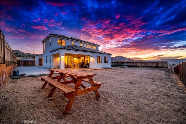 back house at dusk with a patio