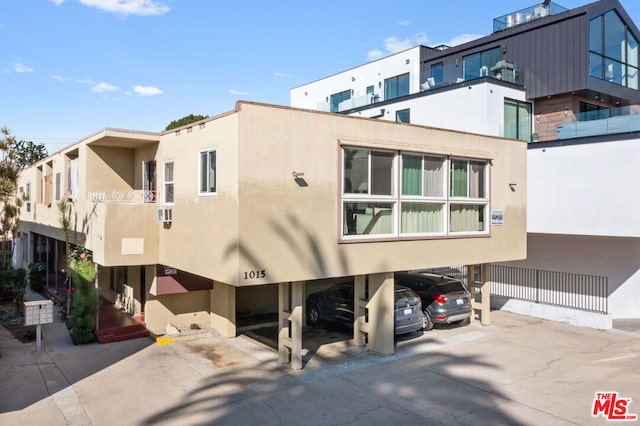 rear view of property with a balcony and a carport