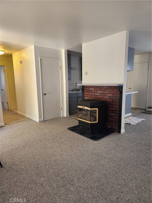 carpeted living room with a wood stove