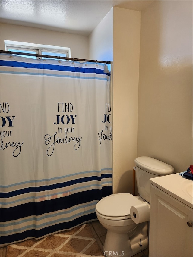 bathroom with vanity, toilet, and curtained shower