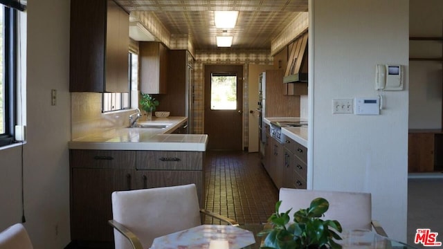 kitchen featuring backsplash, sink, kitchen peninsula, and cooktop