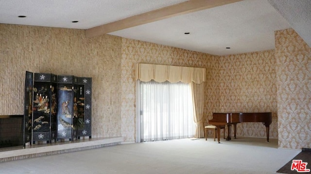 unfurnished room featuring a textured ceiling, beamed ceiling, and carpet flooring