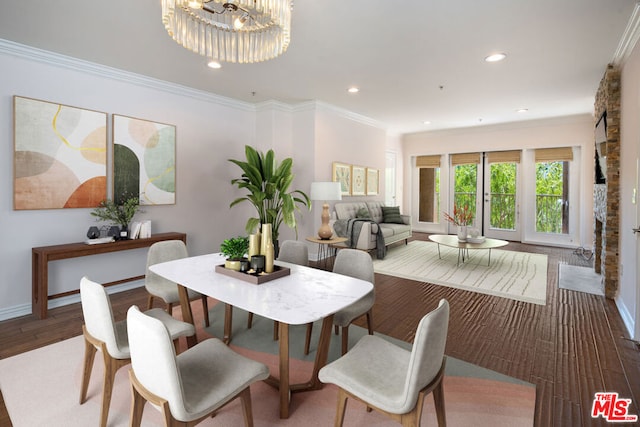 dining room with a chandelier, wood-type flooring, and crown molding