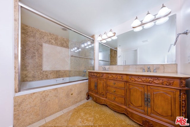 bathroom with tile patterned flooring, vanity, and shower / bath combination with glass door