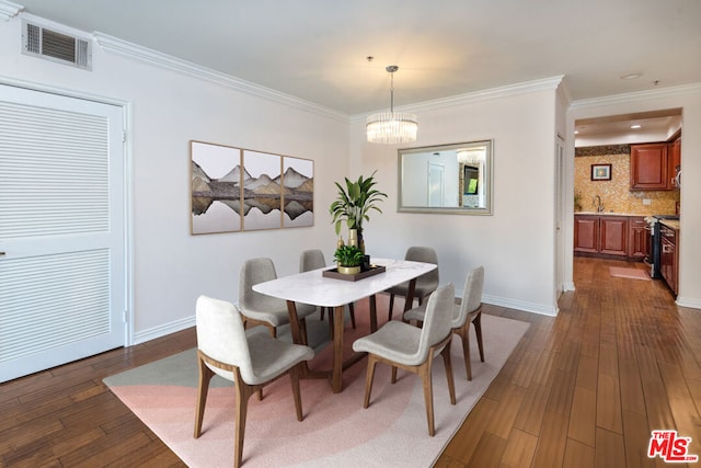 dining room featuring a chandelier, dark hardwood / wood-style flooring, crown molding, and sink