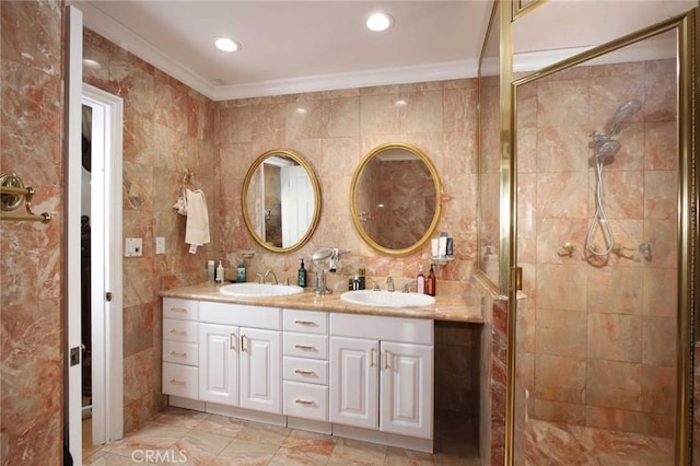 bathroom featuring vanity, a shower with door, tile walls, and crown molding