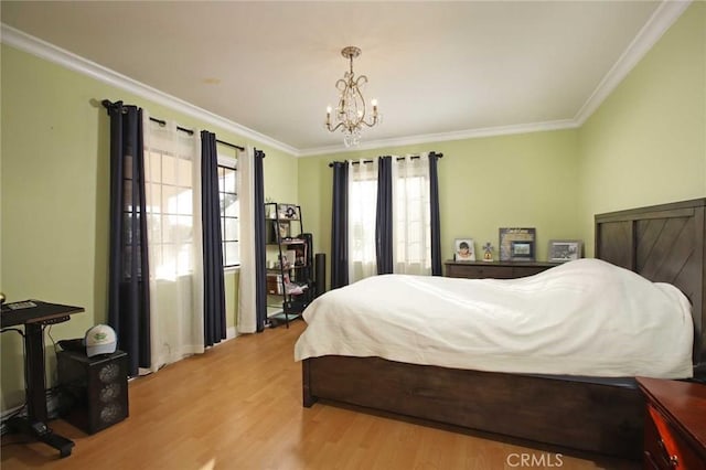 bedroom featuring light wood-type flooring, ornamental molding, and a notable chandelier