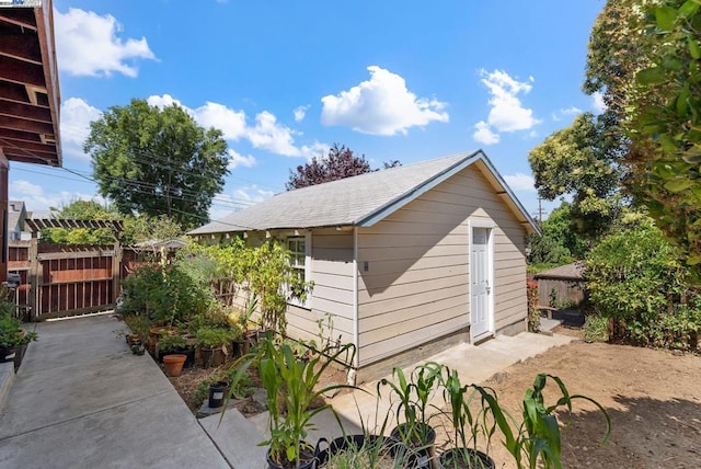 view of home's exterior with a patio and a storage shed