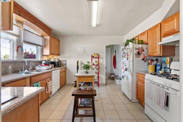 kitchen with white appliances, sink, light tile patterned floors, and backsplash