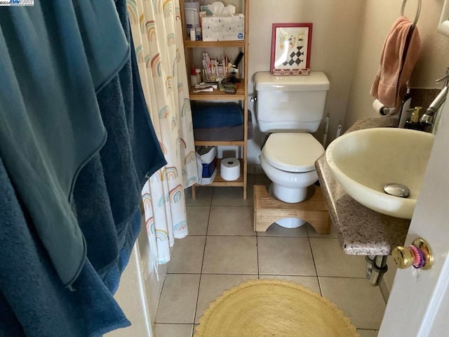 bathroom featuring a shower with curtain, toilet, and tile patterned floors