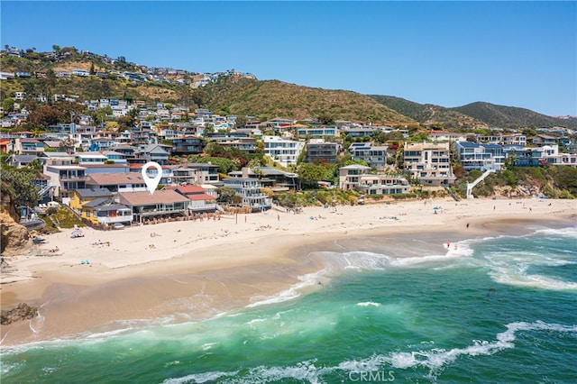 birds eye view of property featuring a water and mountain view and a beach view