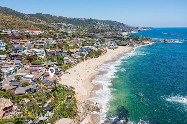 birds eye view of property with a water and mountain view and a view of the beach