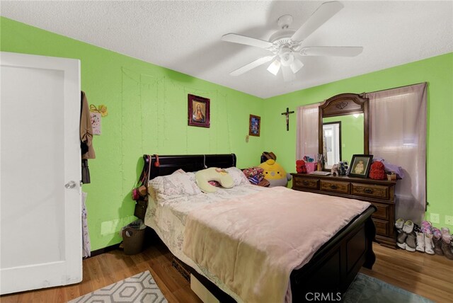 bedroom featuring hardwood / wood-style floors, ceiling fan, and a textured ceiling