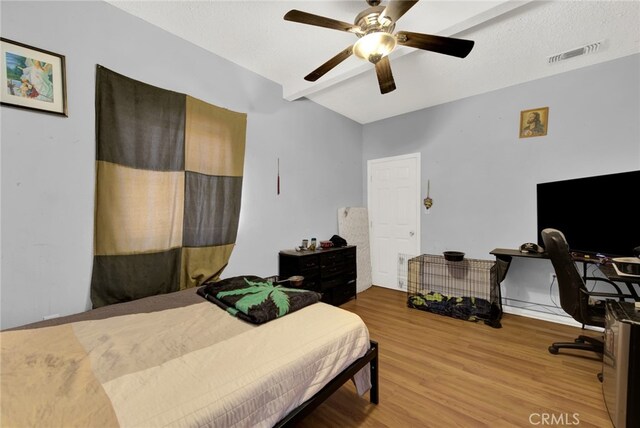 bedroom with beam ceiling, ceiling fan, and hardwood / wood-style flooring