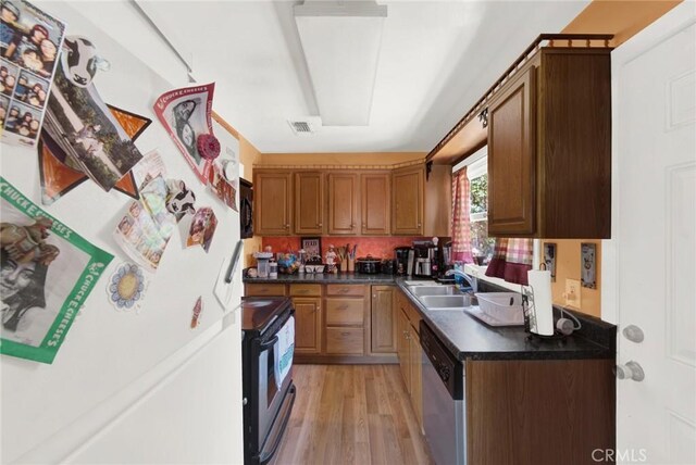 kitchen featuring stainless steel dishwasher, sink, light hardwood / wood-style flooring, range, and white fridge