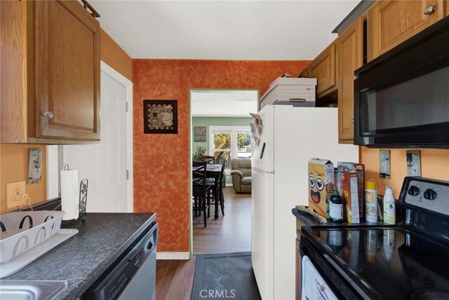 kitchen with black appliances and dark hardwood / wood-style flooring