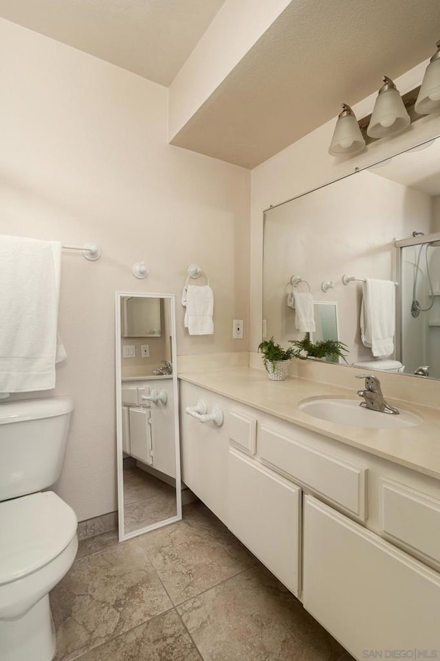 bathroom featuring vanity, toilet, and a shower with door