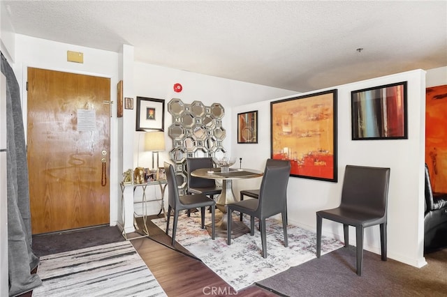 dining room with a textured ceiling and hardwood / wood-style flooring