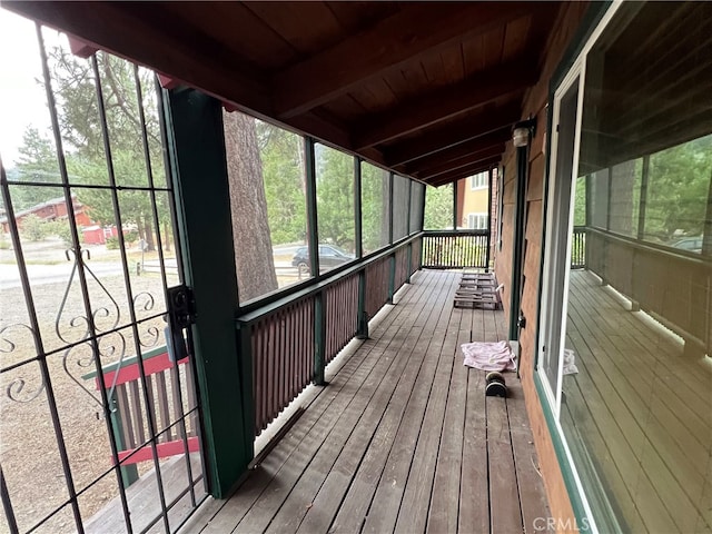 unfurnished sunroom featuring wood ceiling and beamed ceiling