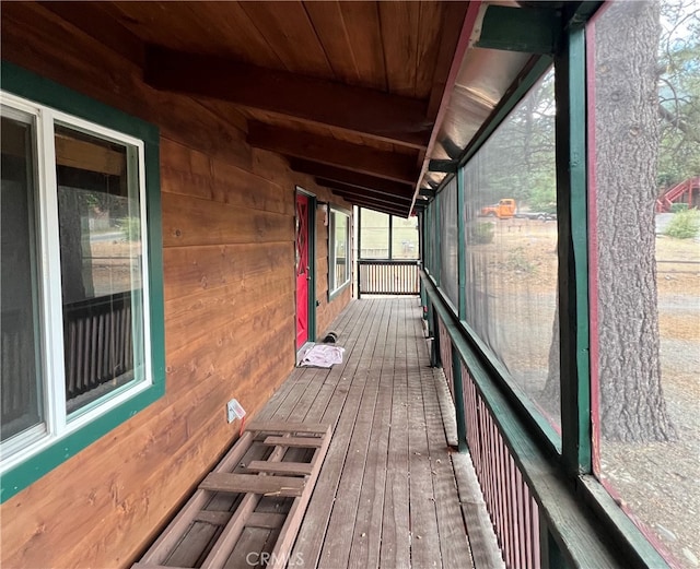 unfurnished sunroom with vaulted ceiling with beams and wooden ceiling