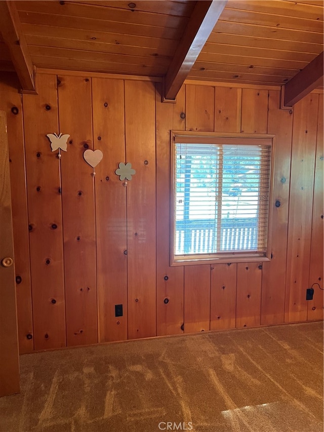 carpeted spare room with wooden walls, wood ceiling, and beam ceiling