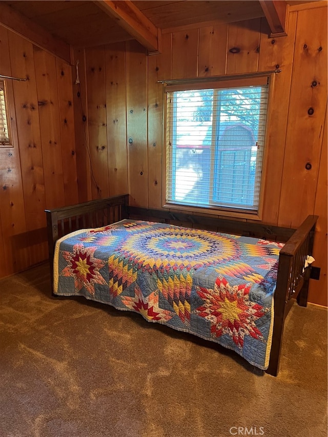 bedroom with beam ceiling, wood ceiling, wood walls, and carpet