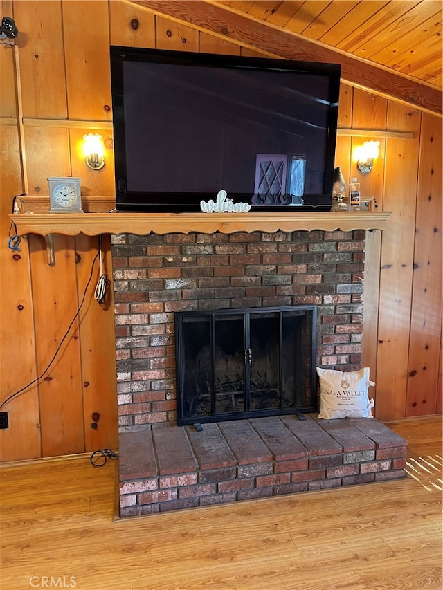 room details with wood ceiling, a brick fireplace, wood-type flooring, and wooden walls