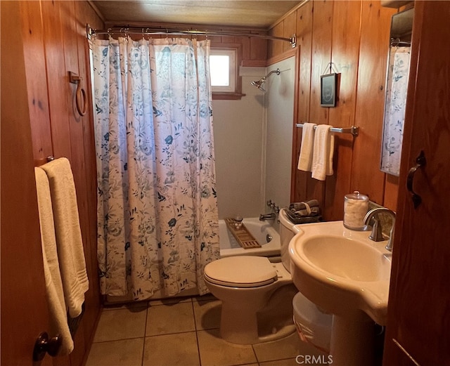 bathroom with tile patterned flooring, wooden walls, toilet, and shower / bathtub combination with curtain