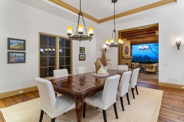 dining area featuring hardwood / wood-style floors, crown molding, and a notable chandelier