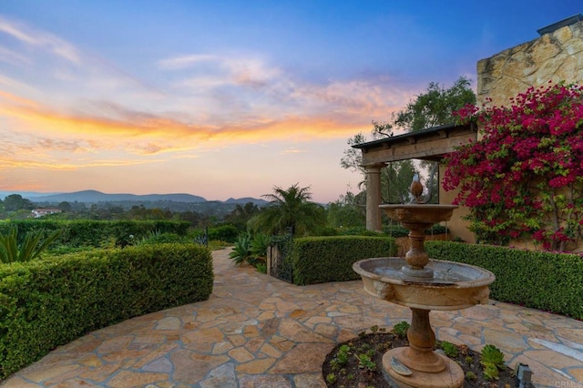 patio terrace at dusk featuring a mountain view