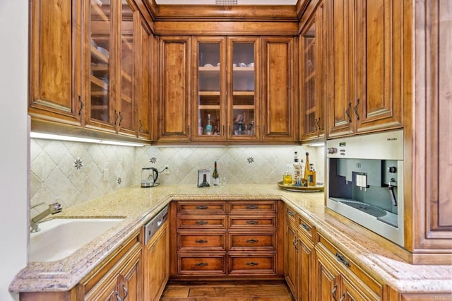 kitchen with light stone counters, sink, and tasteful backsplash