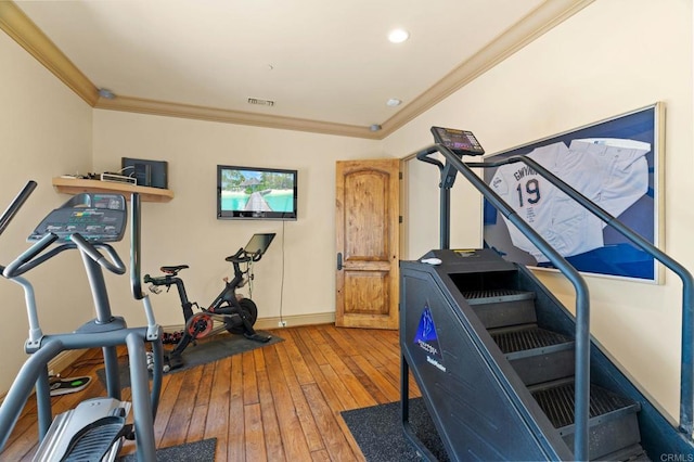 exercise room featuring wood-type flooring and crown molding