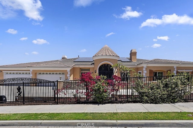 view of front of property with a garage and solar panels