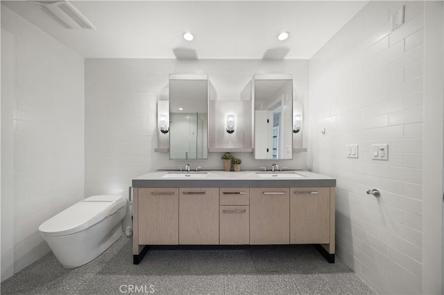 bathroom with vanity, tile walls, and toilet