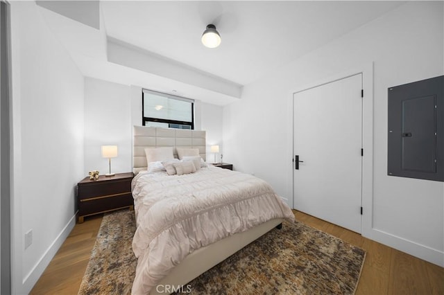 bedroom featuring electric panel and light hardwood / wood-style flooring